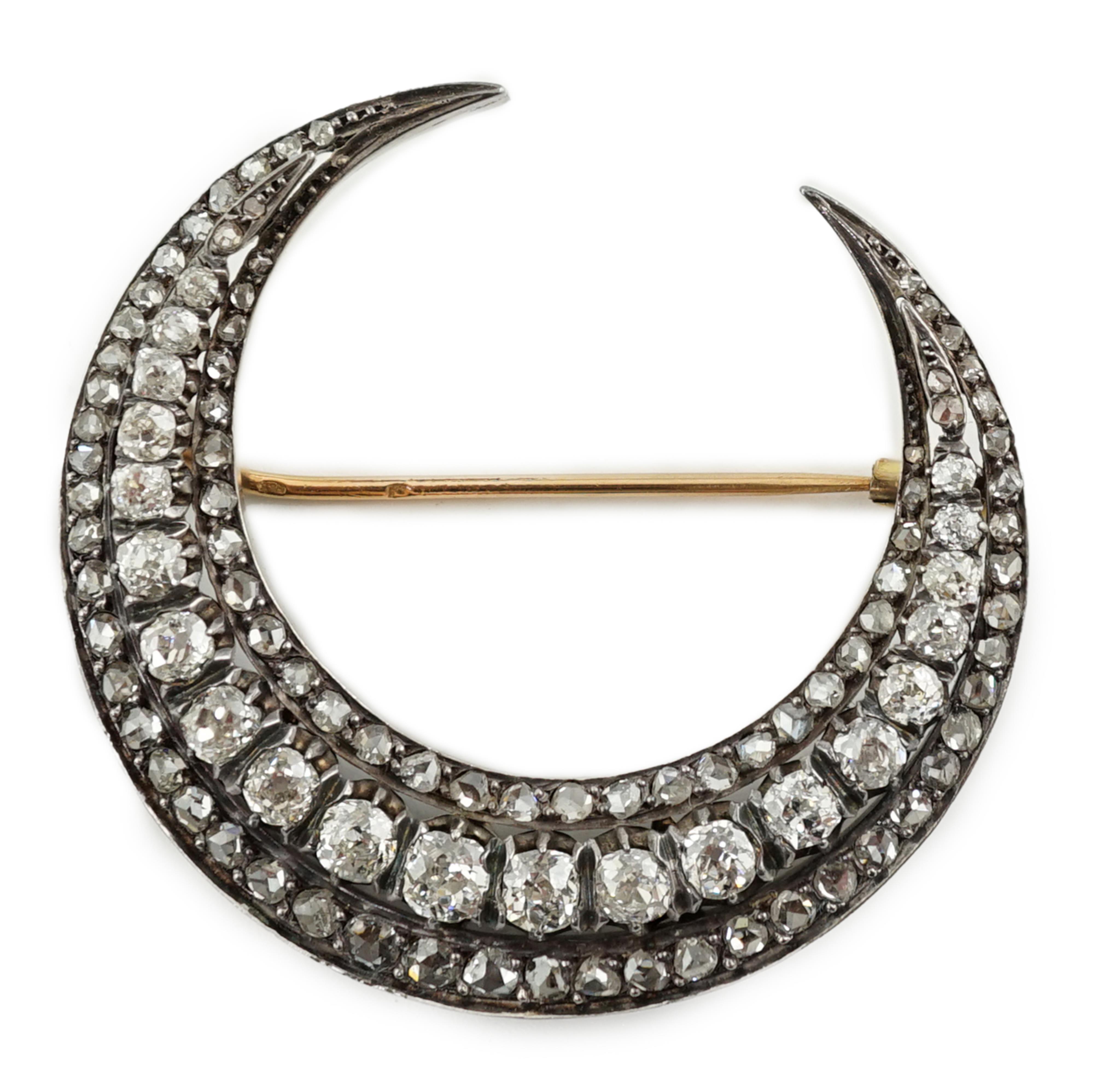 A late 19th/early 20th century French 18ct gold and silver, old mine and rose cut diamond set three row crescent brooch